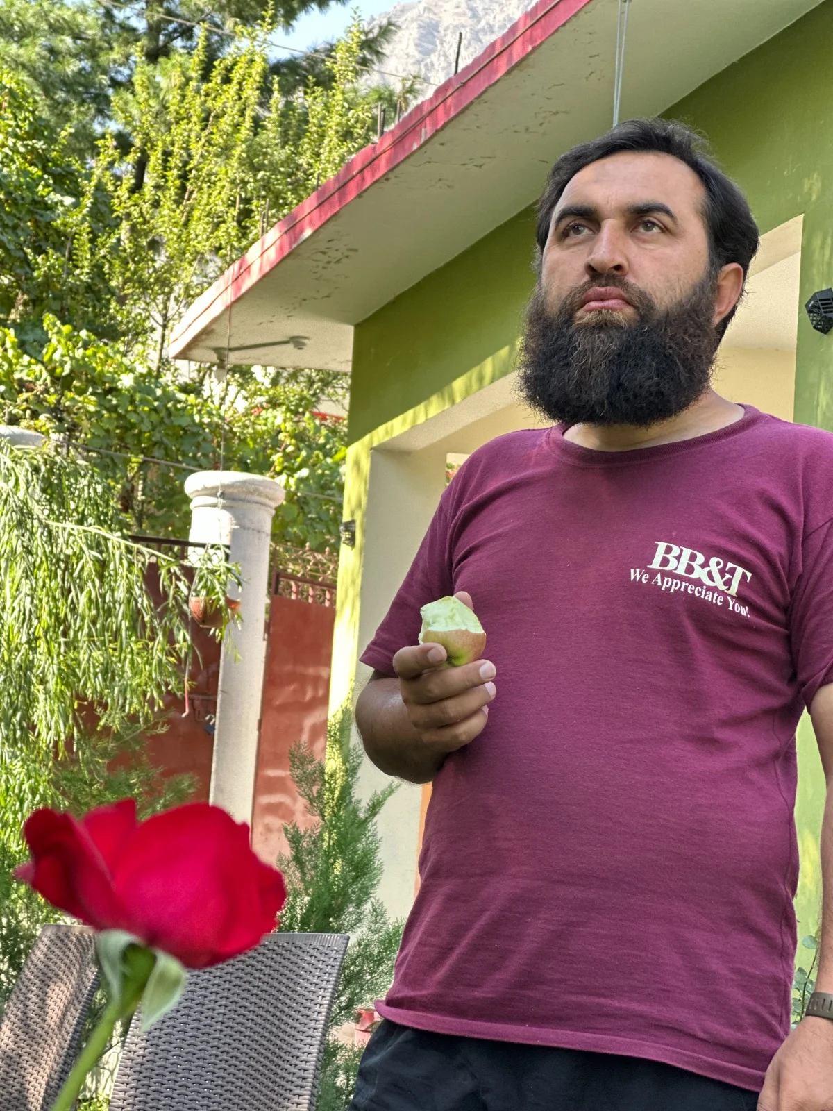 Abdullah in a garden, holding a small cup